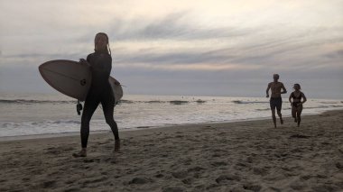 San Diego yakınlarındaki Güney Kaliforniya plajları. Encinitas kıyılarındaki Swamis Resif Sörf Parkı 'nda gün batımları, sörfçüler, gelgit havuzları ve palmiye ağaçları.