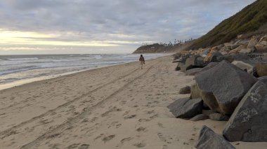 Swamis Sahili 'nin Erimiş Kayalıkları. 50 yıl önce, Swamis Resif Parkı Encinitas 'taki sörf karışımında eski nehir kayaları tarafından çevrelenmiş erozyon kontrol kayaları kıyıya bırakıldı..