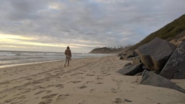 Swamis Sahili 'nin Erimiş Kayalıkları. 50 yıl önce, Swamis Resif Parkı Encinitas 'taki sörf karışımında eski nehir kayaları tarafından çevrelenmiş erozyon kontrol kayaları kıyıya bırakıldı..