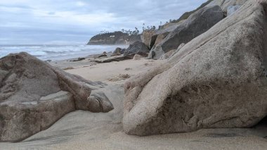  Swamis Sahili 'nde Günbatımı Gökyüzü. Güney Kaliforniya 'nın ücra kumsalları, gün batımları, sörfçüler, gelgit havuzları, dalgalar yontulmuş kayalar, palmiye ağaçları ve San Diego' nun 25 mil kuzeyindeki Encinitas Kayalık Sörf Parkı 'nda şiddetli kış fırtınaları..