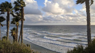Swamis Sahili 'nde Sunset Sky. Güney Kaliforniya 'nın ücra kumsalları, gün batımları, sörfçüler, gelgit havuzları, dalgalar yontulmuş kayalar, palmiye ağaçları ve San Diego' nun 25 mil kuzeyindeki Encinitas Kayalık Sörf Parkı 'nda şiddetli kış fırtınaları..