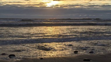 Swamis Sahili 'nde Sunset Sky. Güney Kaliforniya 'nın ücra kumsalları, gün batımları, sörfçüler, gelgit havuzları, dalgalar yontulmuş kayalar, palmiye ağaçları ve San Diego' nun 25 mil kuzeyindeki Encinitas Kayalık Sörf Parkı 'nda şiddetli kış fırtınaları..