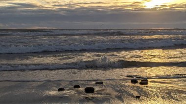 Swamis Sahili 'nde Sunset Sky. Güney Kaliforniya 'nın ücra kumsalları, gün batımları, sörfçüler, gelgit havuzları, dalgalar yontulmuş kayalar, palmiye ağaçları ve San Diego' nun 25 mil kuzeyindeki Encinitas Kayalık Sörf Parkı 'nda şiddetli kış fırtınaları..