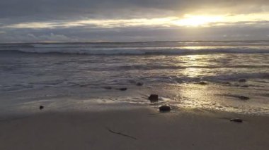 Güney Kaliforniya plaj manzarası - Encinitas California 'daki Swamis Resif Sörf Parkı' nda günbatımı, sörfçüler, gelgit havuzları, dalgalar, kayalar, kum ve palmiye ağaçları.