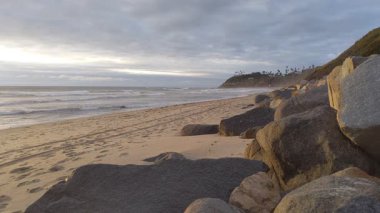 Güney Kaliforniya plaj manzarası - Encinitas California 'daki Swamis Resif Sörf Parkı' nda günbatımı, sörfçüler, gelgit havuzları, dalgalar, kayalar, kum ve palmiye ağaçları.