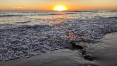 Swamis Sahili 'nde Sunset Sky. Güney Kaliforniya 'nın ücra kumsalları, günbatımları, sörfçüler, gelgit havuzları, dalgalar yontulmuş kayalar, palmiye ağaçları ve San Diego' nun 25 mil kuzeyindeki Encinitas Kayalık Sörf Parkı 'ndaki kış fırtınaları..