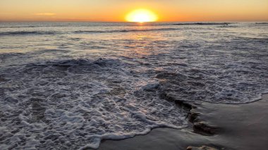 Swamis Sahili 'nde Sunset Sky. Güney Kaliforniya 'nın ücra kumsalları, günbatımları, sörfçüler, gelgit havuzları, dalgalar yontulmuş kayalar, palmiye ağaçları ve San Diego' nun 25 mil kuzeyindeki Encinitas Kayalık Sörf Parkı 'ndaki kış fırtınaları..