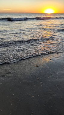 Swamis Sahili 'nde Sunset Sky. Güney Kaliforniya 'nın ücra kumsalları, günbatımları, sörfçüler, gelgit havuzları, dalgalar yontulmuş kayalar, palmiye ağaçları ve San Diego' nun 25 mil kuzeyindeki Encinitas Kayalık Sörf Parkı 'ndaki kış fırtınaları..