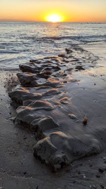 Swamis Sahili 'nde Sunset Sky. Güney Kaliforniya 'nın ücra kumsalları, günbatımları, sörfçüler, gelgit havuzları, dalgalar yontulmuş kayalar, palmiye ağaçları ve San Diego' nun 25 mil kuzeyindeki Encinitas Kayalık Sörf Parkı 'ndaki kış fırtınaları..