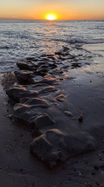Swamis Sahili 'nde Sunset Sky. Güney Kaliforniya 'nın ücra kumsalları, günbatımları, sörfçüler, gelgit havuzları, dalgalar yontulmuş kayalar, palmiye ağaçları ve San Diego' nun 25 mil kuzeyindeki Encinitas Kayalık Sörf Parkı 'ndaki kış fırtınaları..