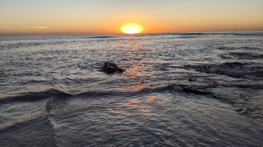 Günbatımında Güney Kaliforniya plaj sahneleri. Swamis Resif Parkı Encinitas California 'da okyanus resifi gel-git havuzları, dalgalar ve karanlık gökyüzü..