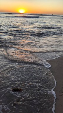 Günbatımında Güney Kaliforniya plaj sahneleri. Swamis Resif Parkı Encinitas California 'da okyanus resifi gel-git havuzları, dalgalar ve karanlık gökyüzü..