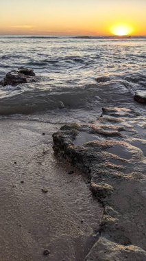 Günbatımında Güney Kaliforniya plaj sahneleri. Swamis Resif Parkı Encinitas California 'da okyanus resifi gel-git havuzları, dalgalar ve karanlık gökyüzü..