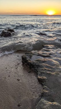 Günbatımında Güney Kaliforniya plaj sahneleri. Swamis Resif Parkı Encinitas California 'da okyanus resifi gel-git havuzları, dalgalar ve karanlık gökyüzü..
