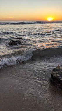 Günbatımında Güney Kaliforniya plaj sahneleri. Swamis Resif Parkı Encinitas California 'da okyanus resifi gel-git havuzları, dalgalar ve karanlık gökyüzü..