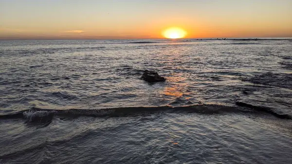 Günbatımında Güney Kaliforniya plaj sahneleri. Swamis Resif Parkı Encinitas California 'da okyanus resifi gel-git havuzları, dalgalar ve karanlık gökyüzü..