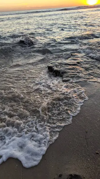 Günbatımında Güney Kaliforniya plaj sahneleri. Swamis Resif Parkı Encinitas California 'da okyanus resifi gel-git havuzları, dalgalar ve karanlık gökyüzü..