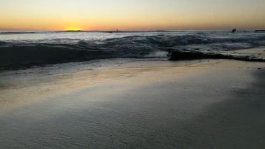 San Diego 'nun kuzeyindeki Güney Kaliforniya plaj sahneleri - Encinitas California' daki Swamis Resif Sörf Parkı 'ndaki altın günbatımları, sörfçüler, gelgit havuzları, dalgalar, kayalar, kumlu plajlar ve palmiye ağaçları.