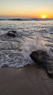 Günbatımında Güney Kaliforniya plaj sahneleri. Antik resif gel-git havuzları, okyanus dalgaları ve Swamis Kayalık Sörf Parkı Encinitas California 'da alacakaranlık renkli gökyüzü..