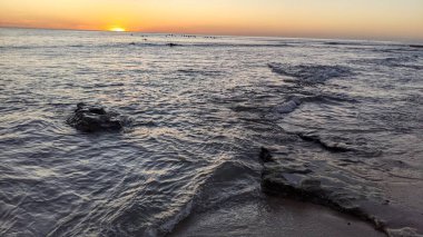 Günbatımında Güney Kaliforniya plaj sahneleri. Antik resif gel-git havuzları, okyanus dalgaları ve Swamis Kayalık Sörf Parkı Encinitas California 'da alacakaranlık renkli gökyüzü..