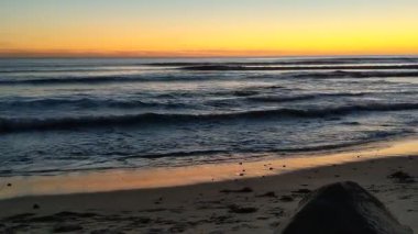 Güney Kaliforniya tenha plajları, altın gün batımları, okyanus dalgaları, sörfçüler, gelgit havuzları ve Encinitas California 'daki Swamis Resif Sörf Parkı' ndaki palmiye ağaçları..