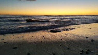 Güney Kaliforniya plaj sahnesi 4K video gelgit havuzları, soyut kaya oluşumları, okyanus dalgaları, sörf tahtaları ile sörfçüler Swamis Resif Parkı Encinitas California 'da sıcak güneşli gökyüzü.