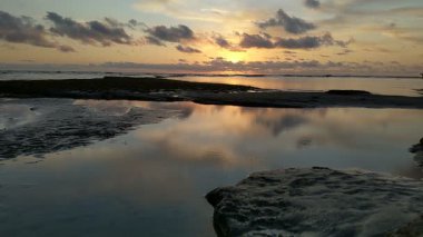 Güney Kaliforniya plaj sahneleri gelgit havuzları, soyut kaya oluşumları, okyanus dalgaları sörf tahtaları, gün batımı siluetleri ve Swamis Resif Parkı Encinitas California 'da sıcak şeftali rengi gökyüzü..