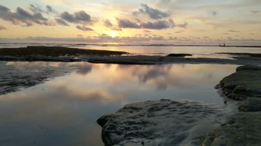 Güney Kaliforniya plaj sahneleri gelgit havuzları, soyut kaya oluşumları, okyanus dalgaları sörf tahtaları, gün batımı siluetleri ve Swamis Resif Parkı Encinitas California 'da sıcak şeftali rengi gökyüzü..