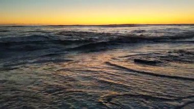 Güney Kaliforniya plaj sahneleri gelgit havuzları, soyut kaya oluşumları, okyanus dalgaları sörf tahtaları, gün batımı siluetleri ve Swamis Resif Parkı Encinitas California 'da sıcak şeftali rengi gökyüzü..