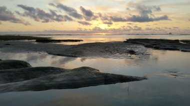 Güney Kaliforniya plaj sahneleri gelgit havuzları, soyut kaya oluşumları, okyanus dalgaları sörf tahtaları, gün batımı siluetleri ve Swamis Resif Parkı Encinitas California 'da sıcak şeftali rengi gökyüzü..