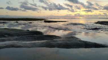 Güney Kaliforniya plaj sahneleri gelgit havuzları, soyut kaya oluşumları, okyanus dalgaları sörf tahtaları, gün batımı siluetleri ve Swamis Resif Parkı Encinitas California 'da sıcak şeftali rengi gökyüzü..