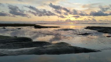Güney Kaliforniya plaj sahneleri gelgit havuzları, soyut kaya oluşumları, okyanus dalgaları sörf tahtaları, gün batımı siluetleri ve Swamis Resif Parkı Encinitas California 'da sıcak şeftali rengi gökyüzü..