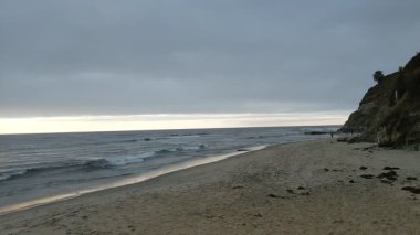 Güney Kaliforniya Pasifik sahili eski resifler, gelgit havuzları, okyanus dalgaları, palmiye ağaçları, sörf tahtaları ve deniz kuşlarının yanı sıra sıcak görünüşlü günbatımı gökyüzü ve Swamis Resif Parkı Encinitas kaya soyutlamaları..