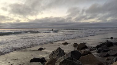 Swamis Resif Sörf Parkı Encinitas California 'da günbatımları, sörfçüler, gelgit havuzları, yıpranmış kaya soyutları ve palmiye ağaçları olan Güney Kaliforniya sahneleri.
