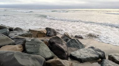 Swamis Resif Sörf Parkı Encinitas California 'da günbatımları, sörfçüler, gelgit havuzları, yıpranmış kaya soyutları ve palmiye ağaçları olan Güney Kaliforniya sahneleri.