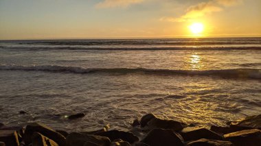Swamis Resif Sörf Parkı Encinitas California 'da günbatımları, sörfçüler, gelgit havuzları, yıpranmış kaya soyutları ve palmiye ağaçları olan Güney Kaliforniya sahneleri.