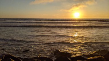 Swamis Resif Sörf Parkı Encinitas California 'da günbatımları, sörfçüler, gelgit havuzları, yıpranmış kaya soyutları ve palmiye ağaçları olan Güney Kaliforniya sahneleri.