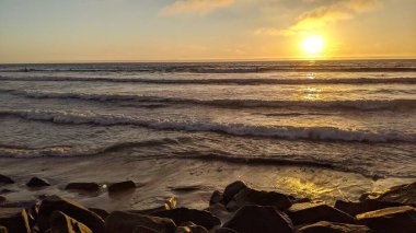 Swamis Resif Sörf Parkı Encinitas California 'da günbatımları, sörfçüler, gelgit havuzları, yıpranmış kaya soyutları ve palmiye ağaçları olan Güney Kaliforniya sahneleri.
