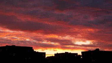 Gökyüzü kırmızı ve turuncu renklerin karışımıyla alevler içinde. Bulutlar sanki bu statik çekimde alev almış gibi görünüyor..