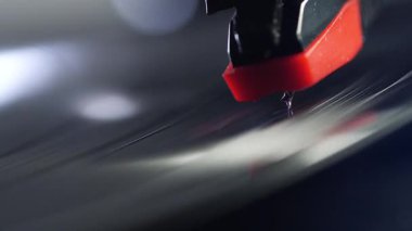 Dönen plağın üzerine konan vinil plak iğnesinin makro çekimi..