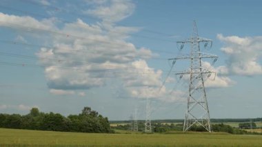 Elektrik direği yeşil alanların üzerinde yükseliyor. Yaz günü