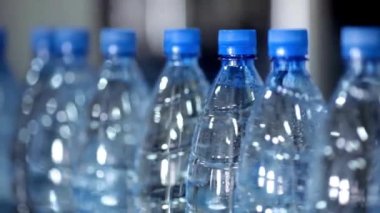 Plastik şişedeki saf temiz suyla dolu şişe taşıyıcı fabrikadan geçiyor. üretim endüstrisi