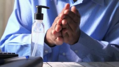 Erkekler ofis alkollü jeli ya da antibakteriyel sabun dezenfekte masasında ellerini temizliyor.
