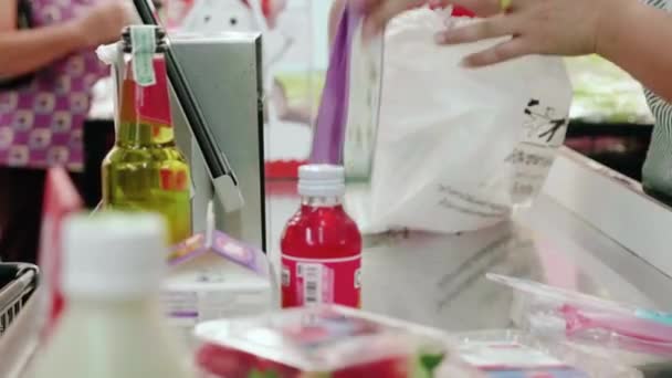 スーパーのレジカウンターレジでレジ係が商品や野菜をスキャン — ストック動画