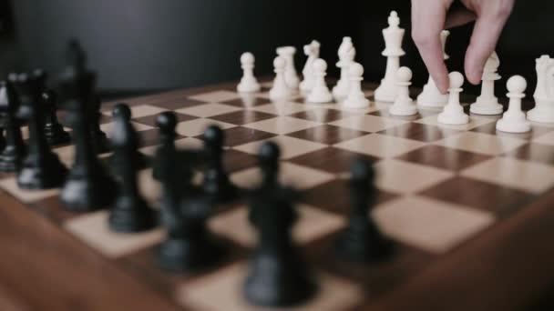 認識できない若いチェスプレーヤーは木の板にチェスの駒で動きを行う ゲームをする — ストック動画