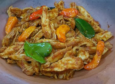 Ayam balado ya da baharatlı tavuk Padang, West Sumatra 'dan geleneksel bir yemektir. Uzun beyaz bir tabakta servis edilen yemekler baharatlı ve yağlıdır. Seçici odak.