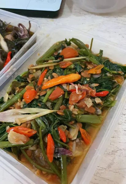 Stir fried water spinach or tumis kangkung is indonesian street food, very famous vegetable dish with bird eye chili