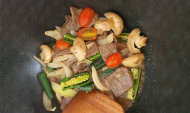 Tumis Daging Sapi Mercon ya da Kızartma ya da sotelenmiş soğanlı biftek, kırmızı arnavut biberi ve diğer bitki ve baharatlar. Beyaz tabakta servis ediliyor. Endonezya yemeği, yemek tarifi ve mutfağı