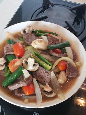 Tumis Daging Sapi Mercon ya da Kızartma ya da sotelenmiş soğanlı biftek, kırmızı arnavut biberi ve diğer bitki ve baharatlar. Beyaz tabakta servis ediliyor. Endonezya yemeği, yemek tarifi ve mutfağı