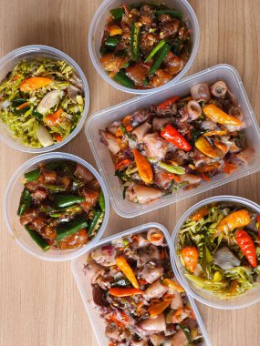 Yemek şirketi fikri, aşçı Asya mutfağı menüsü için yemek siparişi hazırlıyor.